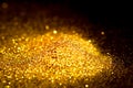Sprinkle glitter gold dust in the dark textured abstract background elegant Royalty Free Stock Photo