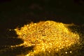 Sprinkle glitter gold dust in the dark textured abstract background elegant Royalty Free Stock Photo