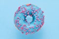 Sprinkled Blue Donut. Glazed sprinkled donut on light blue background.  Top view, copy space Royalty Free Stock Photo