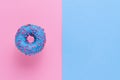 Sprinkled Blue Donut. Glazed sprinkled donut on pink blue background. Top view, copy space Royalty Free Stock Photo