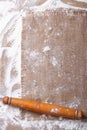 Sprinkled flour and rolling pin on a wooden board and burlap