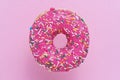 Sprinkled Pink Donut. Glazed sprinkled donut on pink background. Top view, copy space Royalty Free Stock Photo