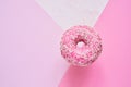 Sprinkled Pink Donut. Glazed sprinkled donut on colorful pink background. Top view, copy space Royalty Free Stock Photo