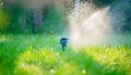 Sprinkler head watering green grass lawn. Gardening concept. Smart garden activated with full automatic sprinkler irrigation syste Royalty Free Stock Photo