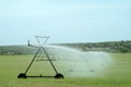 Sprinkler irrigation watering cultivated field Royalty Free Stock Photo