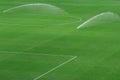 Sprinkler system working on fresh green grass on football soccer stadium Royalty Free Stock Photo