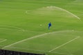 Sprinkler system working on fresh green grass on football soccer stadium