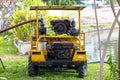 Sprinkler truck small old yellow water pump is watering trees in park. with old engine that works well.