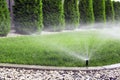 Sprinklers watering grass, green lawn in garden Royalty Free Stock Photo