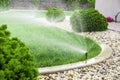 Sprinklers watering lawn in garden Royalty Free Stock Photo
