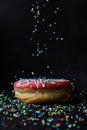 Sprinkles falling onto donut