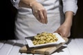 Sprinkling parsley flakes on bowtie pasta Royalty Free Stock Photo