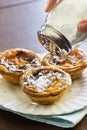 Sprinkling Powdered Sugar Over Pasteis de Nata Royalty Free Stock Photo