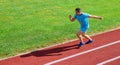 Sprinter training at stadium track. Runner captured in midair. Short distance running challenge. Boost speed. Athlete