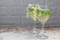 Spritzer cocktail with white wine, mint and ice, decorated with spiral lemon zest, copy space