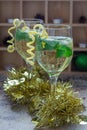 Spritzer cocktail with white wine, mint and ice, decorated with spiral lemon zest