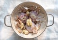 sprouted garlic placed in a bowl. many peeled and unpeeled garlics are together.