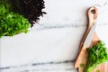 Sprouts on a wood board with a knife on a marble surface and lettuce