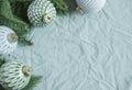 Spruce twigs with Christmas decorations on the green linen crumpled textile background