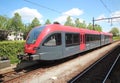 Spurt train in red and black of R-NET on Merwedelingelijn along platform at station Dordrecht