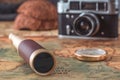 Spyglass and a brass compass lie on an old map against the background of a vintage film camera. Royalty Free Stock Photo