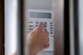 Spying a man arming a burglar alarm system