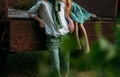 Spying. a barefooted girl in a green dress sits on the back of a car and hugs a barefoot, next to a standing guy, a summer day in Royalty Free Stock Photo