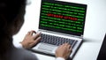 Spyware attack on laptop computer, woman working in office, cybercrime, close up