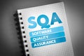 SQA - Software Quality Assurance acronym on notepad, business concept background