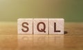 SQL text Structured Query Language on wooden cubes on a green-brown background