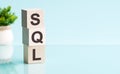 SQL word in wooden blocks on table. blue background, copy space