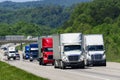 A squadron of eighteen-wheelers lead the way down an interstate highway in eastern Tennessee