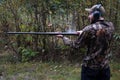 A man ejects a shotgun shell from an old gun with steam coming out of the action