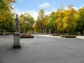 Square and alley with sculptures among yellow trees in the Saxon Garden in Warsaw, Poland. Beautiful autumn landscape of a city