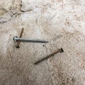 Square background with rusty screws on concrete surface