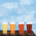 Square banner with craft beer in pilsner glasses. Wooden table against the background of the sea and blue sky. Light and Royalty Free Stock Photo