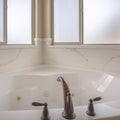 Square Bathroom interior of a home with polished bathtub and frosted windows