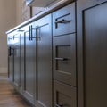 Square Beautiful cabinetry with black handles and drawers under white countertop