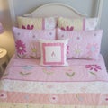 Square Bedroom interior with colorful printed feminine beddings pn the single bed