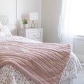 Square Bedroom interior with floral feminine beddings and decorative headboard on bed