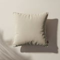 Square beige pillow with a subtle texture, centered against a light background. The Royalty Free Stock Photo