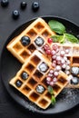 Square belgian waffles with berries and confectionery sugar