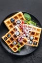 Square belgian waffles with berries and icing sugar