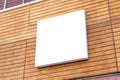 Square billboard mockup on wooden building wall