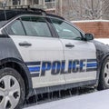 Square Black and white police car parked in the neighborhood on a snowy and rainy day Royalty Free Stock Photo