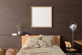 Square blank poster frame mock up on the brown  concrete wall in interior of industrial bedroom Royalty Free Stock Photo