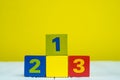 Square block puzzle number 1 2 and 3 on table with yellow wall background Royalty Free Stock Photo