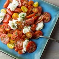 Overhead view of sliced red and yellow heirloom tomatoes and mozzarella cheese in a caprese salad. Royalty Free Stock Photo