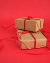 Square box wrapped in brown kraft paper and tied with a red thin silk ribbon Royalty Free Stock Photo