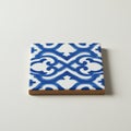 A square ceramic tile with a white background features an intricate, symmetrical blue Royalty Free Stock Photo